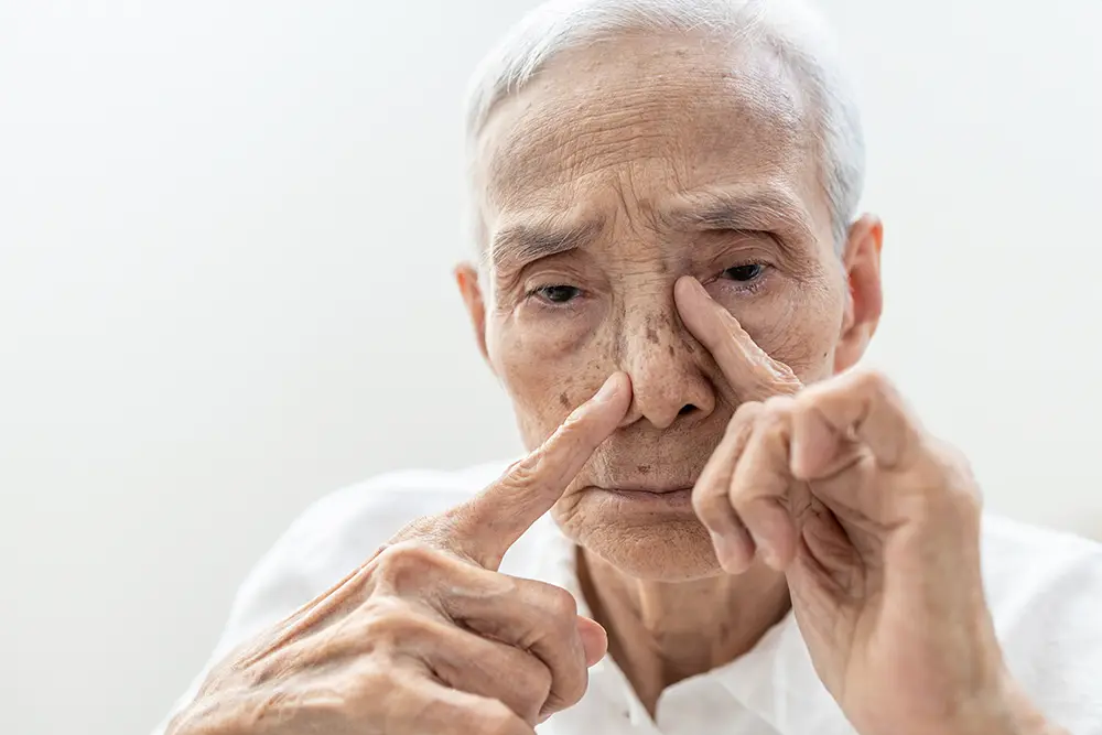 Elderly man massaging his nose