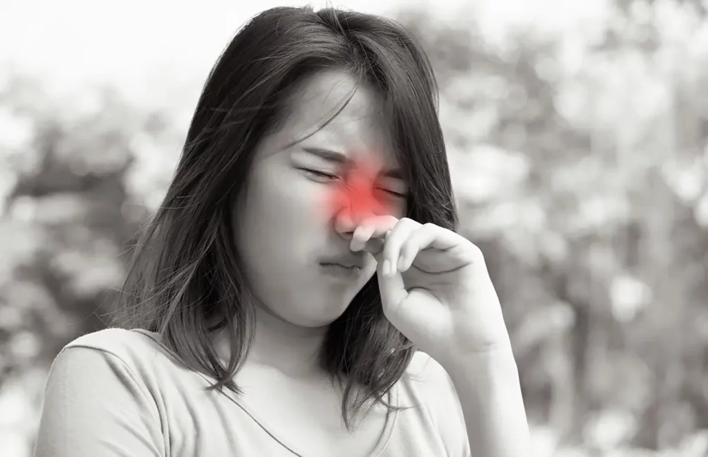 A woman with her hand right under her nose and the nasopharyngeal area red